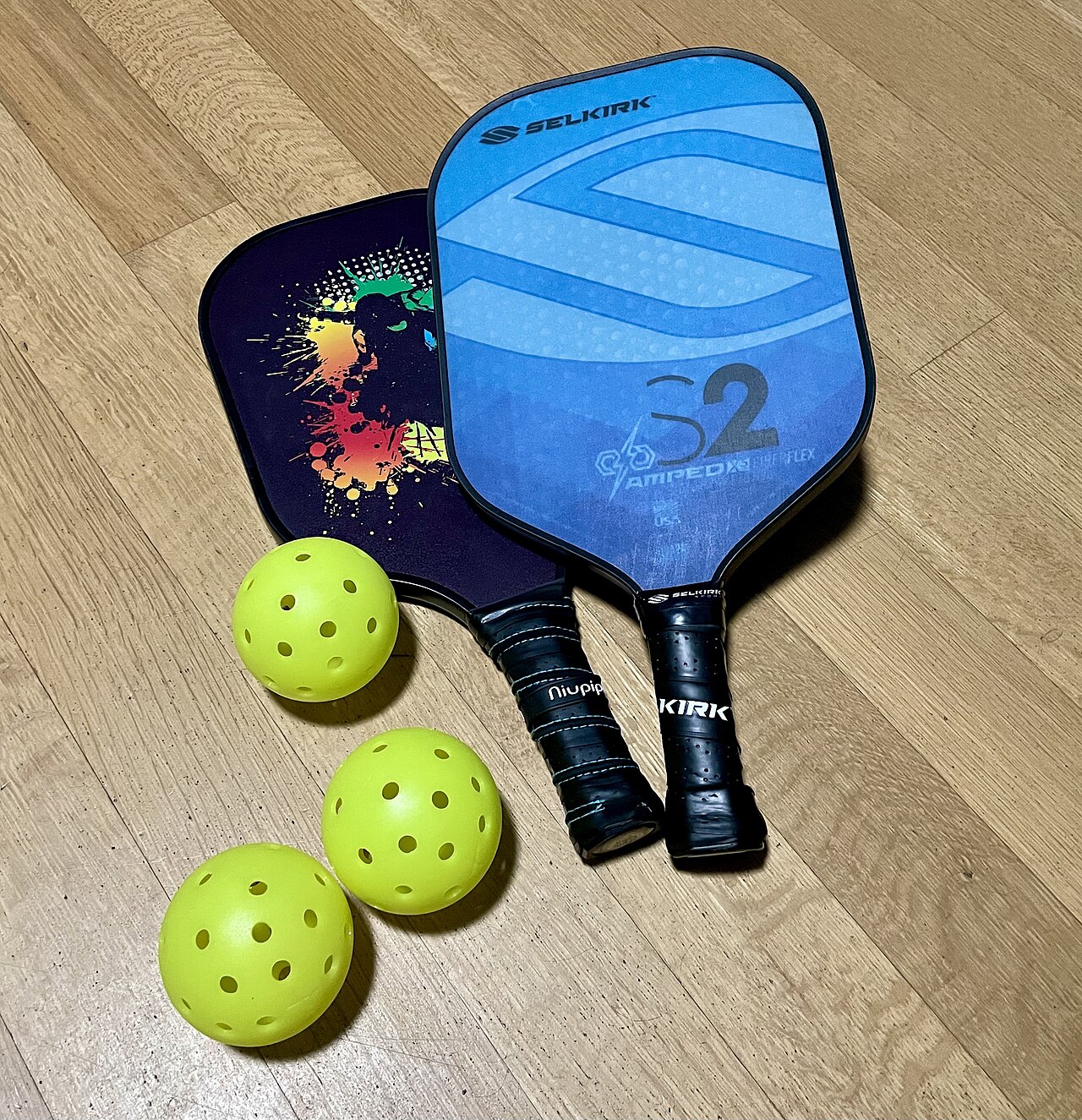 Pickleball balls and paddles laid out together