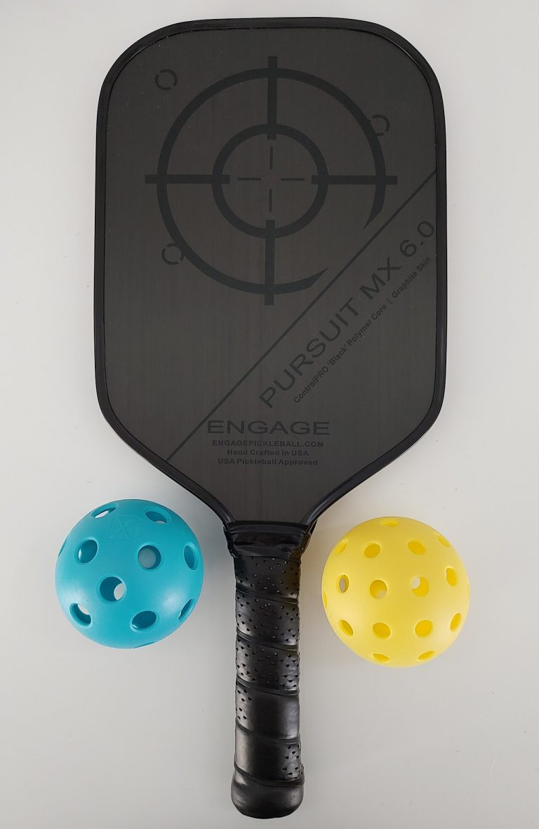 A pickleball paddle resting with two pickleballs